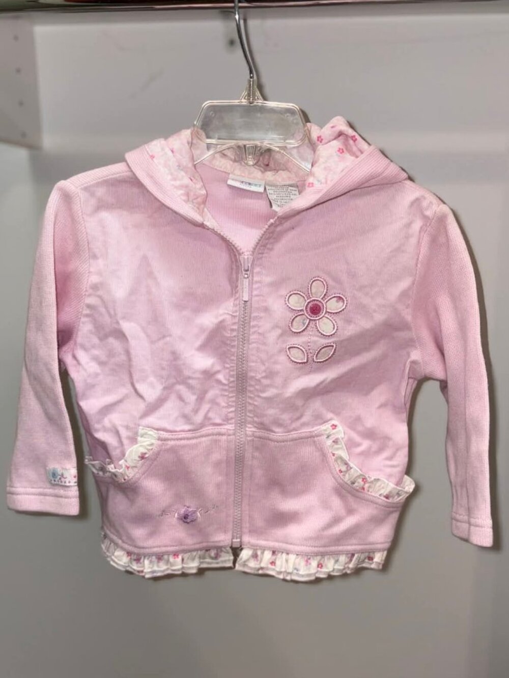 Brand new girls all-weather jacket. 18 months. Front zip, cute ruffles, hood.